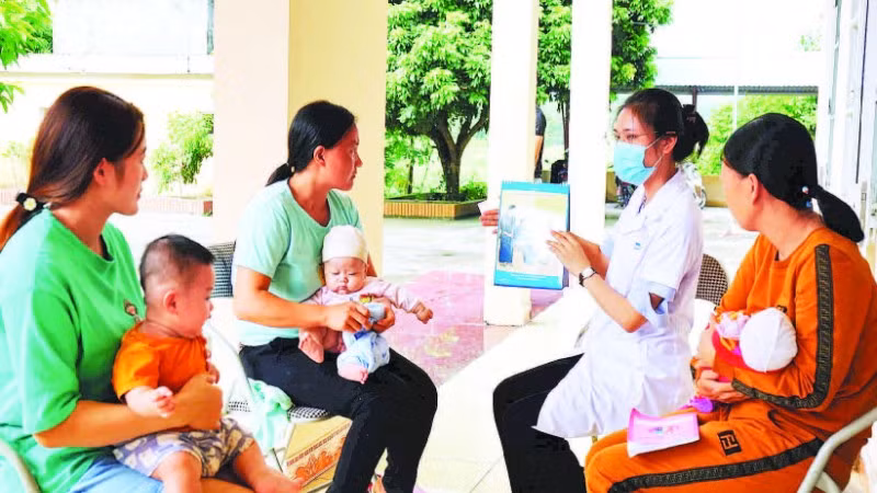 Cán bộ Trạm y tế xã Sảng Mộc, tỉnh Thái Nguyên tư vấn cho các bà mẹ về lợi ích khi tiêm vắc-xin cho trẻ.