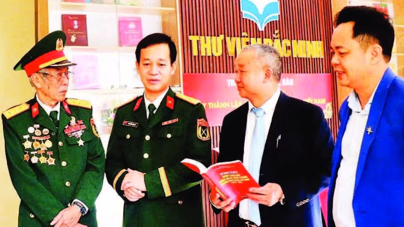 Giám đốc Thư viện Bắc Ninh số 1 Nguyễn Đắc Hồng (thứ hai, từ phải sang) trao đổi với độc giả tại một cuộc trưng bày sách.