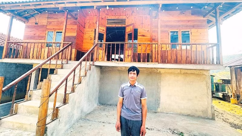 Anh A Đruộng cùng ngôi nhà sàn phục vụ lưu trú trong không gian truyền thống người Mơ Nâm.