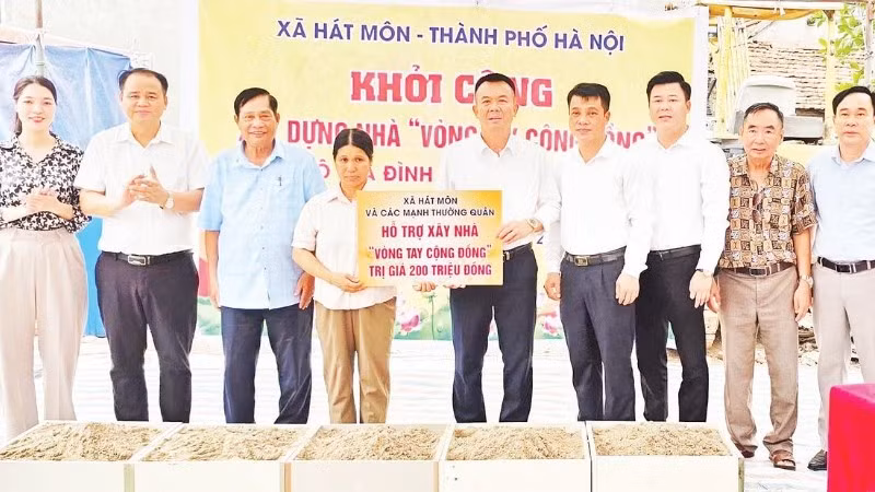 Bí thư Đảng ủy xã Hát Môn trao tiền hỗ trợ người dân xây dựng nhà ở.
