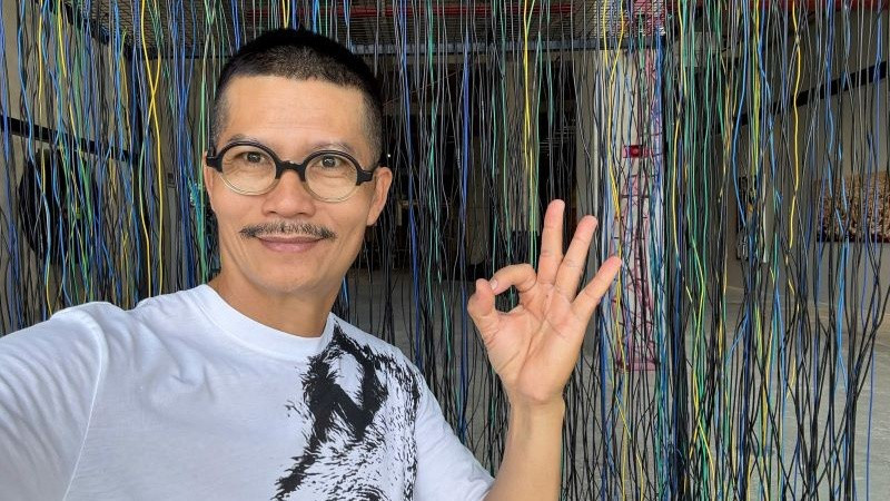 Họa sĩ Nguyễn Ngọc Dân tại triển lãm trưng bày tác phẩm của anh.