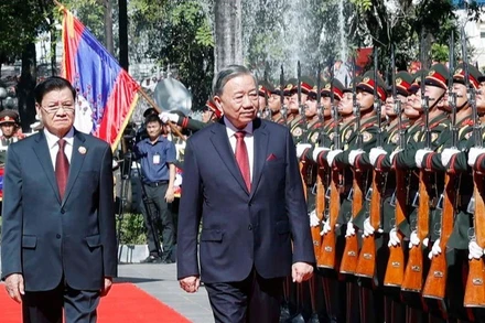 Tổng Bí thư, Chủ tịch nước Lào Thongloun Sisoulith và Tổng Bí thư Tô Lâm duyệt Đội danh dự Quân đội nhân dân Lào tại Lễ đón trọng thể Tổng Bí thư Tô Lâm và Phu nhân tại thủ đô Viêng Chăn, Lào sáng 1/12. (Ảnh: Thống Nhất/TTXVN)