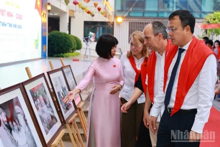 Hiệu trưởng Trường tiểu học Việt Nam-Cuba Trần Thị Tố Trinh giới thiệu với Đại sứ Cuba tại Việt Nam Rogelio Polanco Fuentes và các đại biểu về các tác phẩm tranh ảnh trưng bày tại Triển lãm.