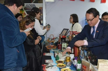 Đại sứ Việt Nam tại Chile Nguyễn Việt Cường giới thiệu các sản phẩm cà-phê của Việt Nam với khách tham quan Hội chợ. (Ảnh: Đại sứ quán Việt Nam tại Chile)
