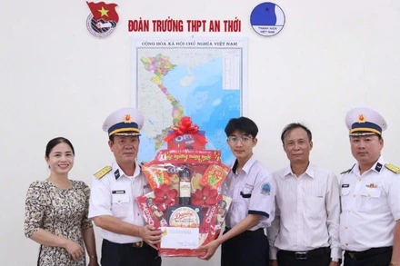 Thượng tá Đoàn Văn Khương, Phó Lữ đoàn trưởng Lữ đoàn 127 trao quà cho con ngư dân. (Ảnh do Vùng 5 Hải quân cung cấp)