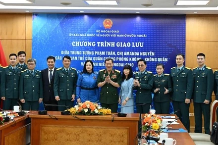 Trung tướng Phạm Tuân và nữ phi hành gia Amanda Nguyễn chụp ảnh kỷ niệm với các đại biểu tham gia giao lưu. (Ảnh: Ủy ban Nhà nước về người Việt Nam ở nước ngoài cung cấp)