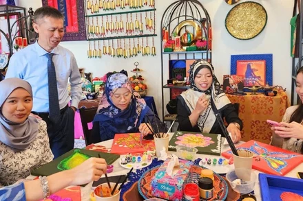 Tiến sĩ Trần Trọng Nghĩa và sinh viên Đại học Quốc gia Brunei trải nghiệm hoạt động trang trí họa tiết truyền thống của Việt Nam và Brunei Darussalam. (Ảnh do Đại sứ quán Việt Nam tại Brunei cung cấp)