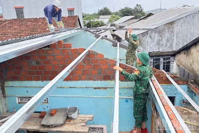 Cán bộ và chiến sĩ Đồn Biên phòng cửa khẩu cảng Dung Quất sửa chữa, xây dựng nhà cho người dân ven biển.