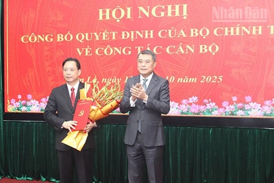 Đồng chí Lê Minh Hưng, Ủy viên Bộ Chính trị, Bí thư Trung ương Đảng, Trưởng ban Tổ chức Trung ương trao quyết định của Bộ Chính trị và tặng hoa chúc mừng đồng chí Hoàng Văn Nghiệm.