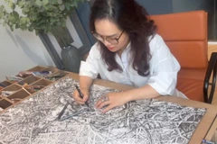 Họa sĩ Hoàng Thị Thu Hà miệt mài bên tác phẩm.