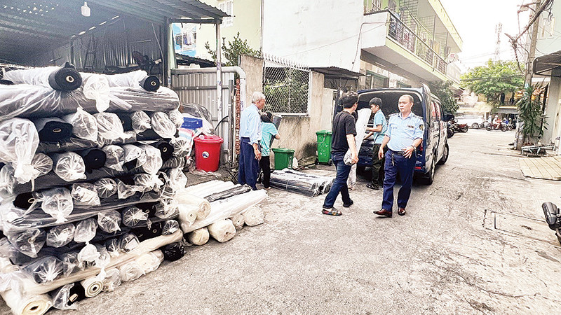 Cán bộ Đội Quản lý thị trường số 8 tiến hành kiểm tra kho vải trên địa bàn quận Tân Bình. (Ảnh CỤC QUẢN LÝ THỊ TRƯỜNG THÀNH PHỐ HỒ CHÍ MINH)