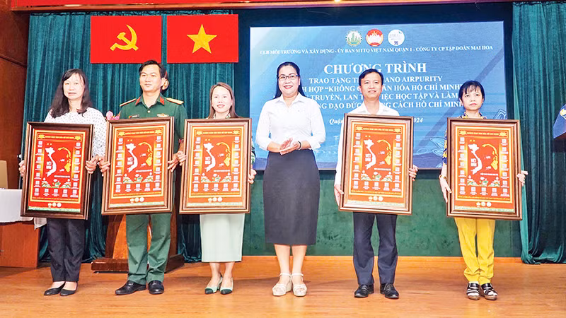 Các thành viên Mặt trận Tổ quốc Quận 1 tiếp nhận tranh "Không gian văn hóa Hồ Chí Minh" tích hợp mã QR.