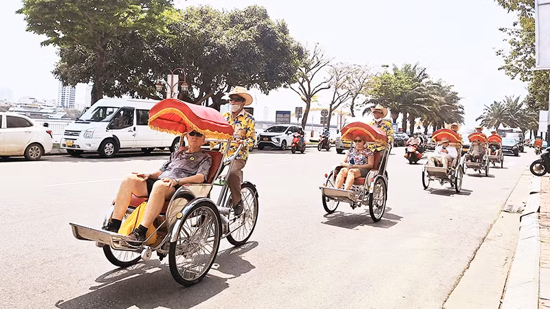 Du khách nước ngoài trải nghiệm tham quan thành phố Đà Nẵng bằng xích-lô.