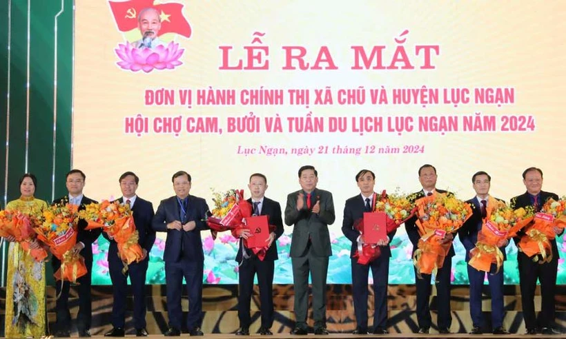 Các đồng chí: Nguyễn Văn Gấu, Phan Thế Tuấn trao quyết định, tặng hoa chúc mừng lãnh đạo thị xã Chũ và huyện Lục Ngạn.