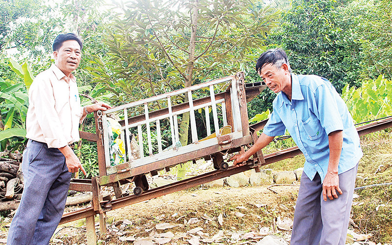 Một phần hệ thống máy vận chuyển trên địa hình dốc của ông Trần Văn Túy (bên phải).