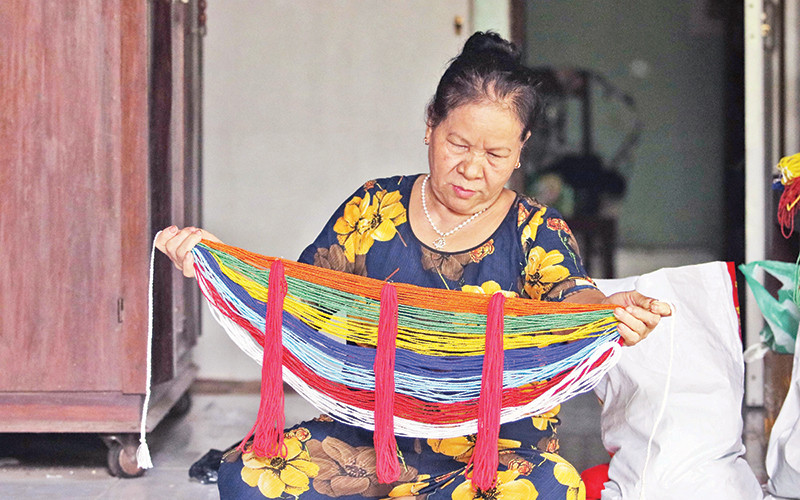 Bà Hồ Thị Non giới thiệu vòng cườm đá đeo ở lưng của người Cor. 