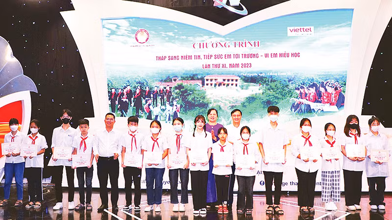 Đại diện lãnh đạo tỉnh và Hội khuyến học tỉnh Thái Nguyên trao học bổng cho các em học sinh. (Ảnh TRƯỜNG SƠN)