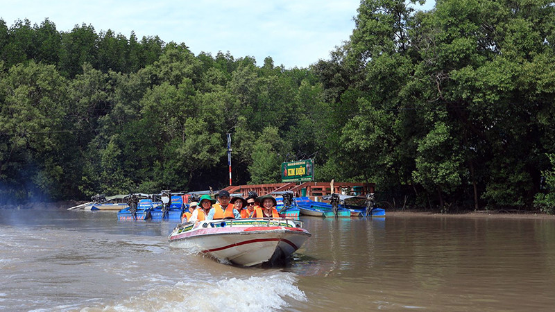 Du khách trải nghiệm đi ca-nô khám phá miệt vườn, kênh rạch Cà Mau.