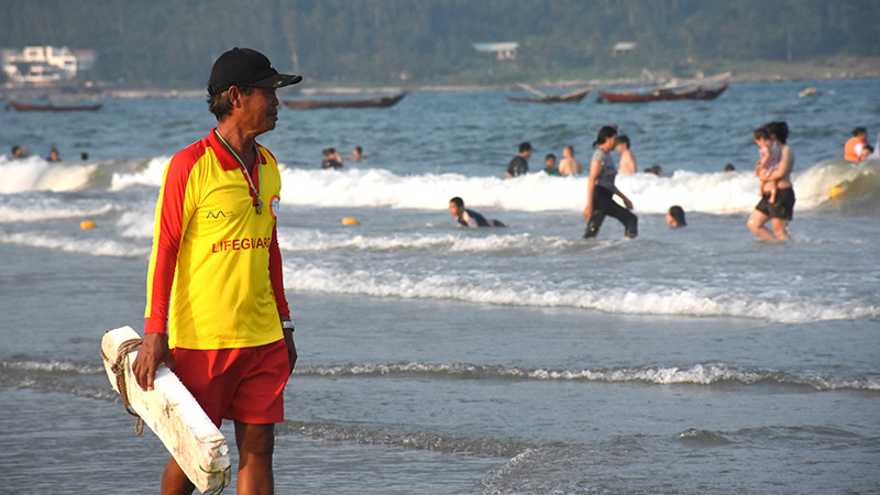 Ông Đặng Cư, một nhân viên cứu hộ lâu năm, chăm chú quan sát bao quát khu vực biển du khách đang tắm.