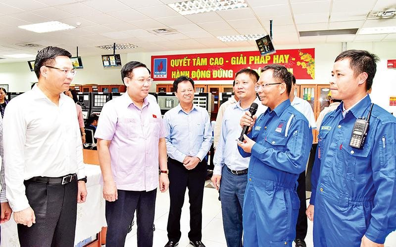 Chủ tịch Quốc hội Vương Đình Huệ nghe giới thiệu về Phòng điều khiển trung tâm tại Công ty cổ phần lọc hóa dầu Bình Sơn. (Ảnh VIẾT CHUNG)