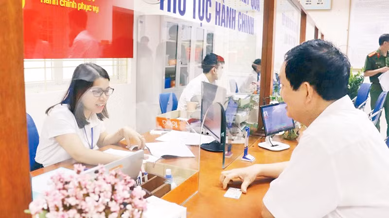 Cán bộ phường Mỹ Đình 1, quận Nam Từ Liêm hướng dẫn người dân thực hiện thủ tục hành chính. (Ảnh CHIẾN CÔNG)