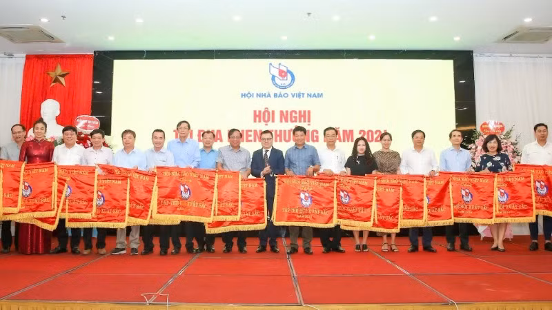 Chủ tịch Hội Nhà báo Việt Nam Lê Quốc Minh trao Cờ thi đua tặng tập thể có thành tích xuất sắc.