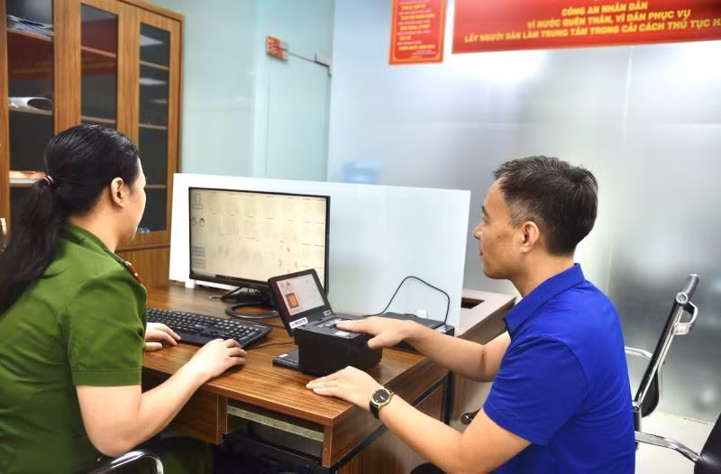 Cán bộ công an thực hiện lấy dấu vân tay của người dân.