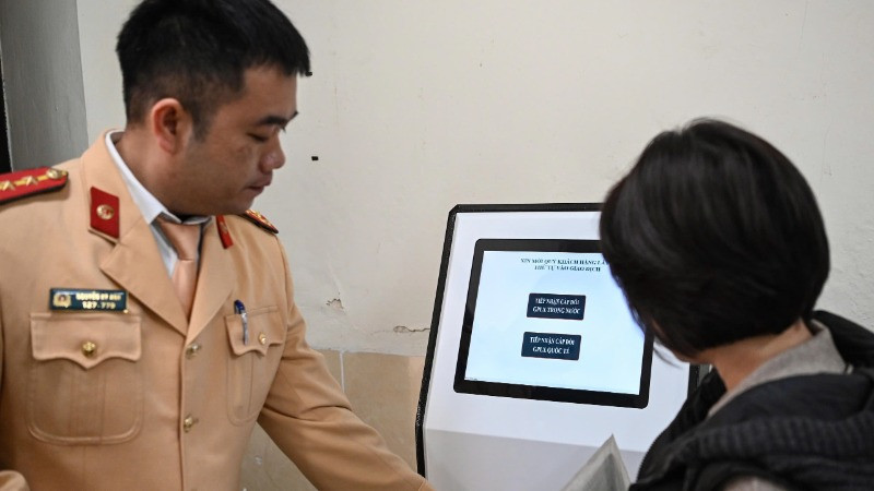 Lực lượng Công an hướng dẫn người dân gửi hồ sơ trực tuyến cấp đổi giấy phép lái xe.