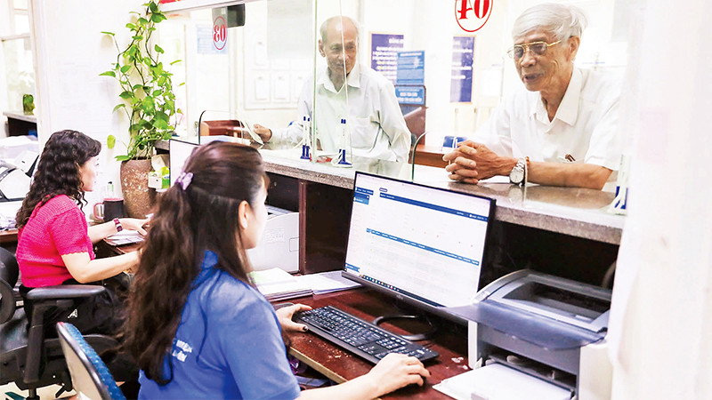 Người dân làm thủ tục bảo hiểm xã hội, bảo hiểm y tế tại bộ phận một cửa của Bảo hiểm xã hội tỉnh Nghệ An. (Ảnh ĐỨC ANH)