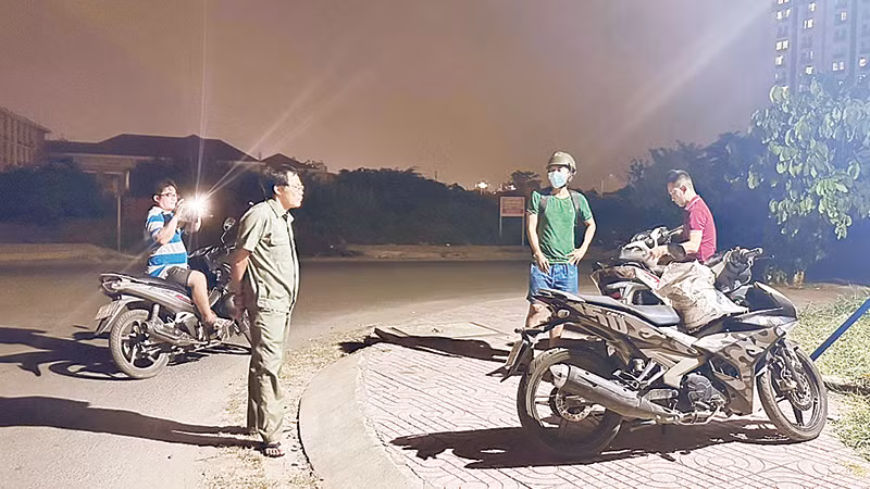 Các thành viên Tổ tự quản bảo vệ môi trường Khu phố 5, Phường 14 xử lý hành chính một người dân đổ trộm rác.