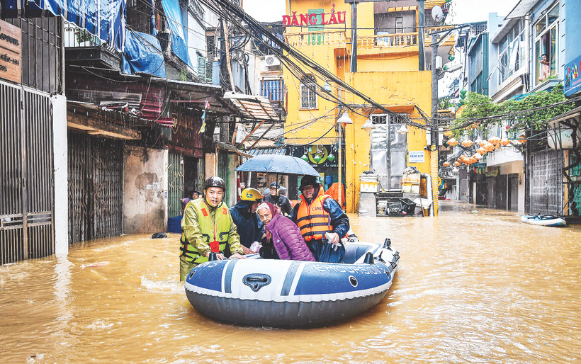 Lực lượng chức năng ứng cứu, giúp người dân khu vực phường Phúc Tân (quận Hoàn Kiếm, Hà Nội) di chuyển đến nơi an toàn khi nước lũ lên nhanh, nhiều khu vực bị ngập sâu. Ảnh: Thành Đạt