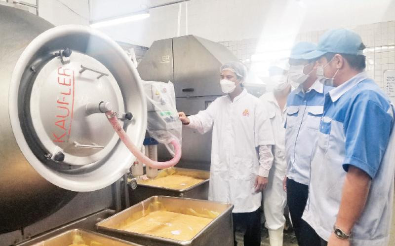 Kỹ sư Bùi Trọng Hữu (ngoài cùng bên trái) và nhân viên kỹ thuật vận hành bồn massage dây chuyền sản xuất thịt nguội, một sáng kiến sửa chữa máy do anh thực hiện.