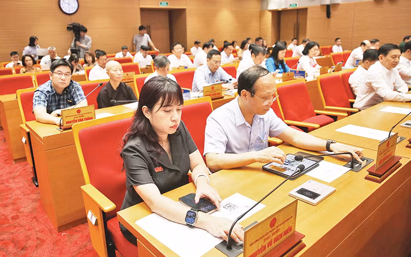 Đại biểu Hội đồng nhân dân thành phố Hà Nội biểu quyết thông qua Đề án sắp xếp đơn vị hành chính cấp huyện, cấp xã thành phố Hà Nội giai đoạn 2023-2025. (Ảnh THÀNH NGUYỄN)