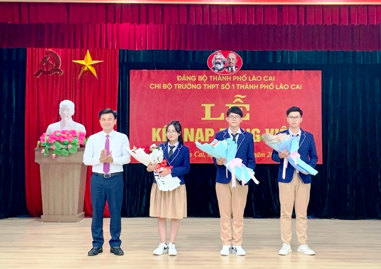 Lãnh đạo Thành ủy Lào Cai tặng hoa chúc mừng 3 đảng viên mới là học sinh Trường Trung học phổ thông số 1 thành phố Lào Cai. (Ảnh: NGUYỄN NHIN) 