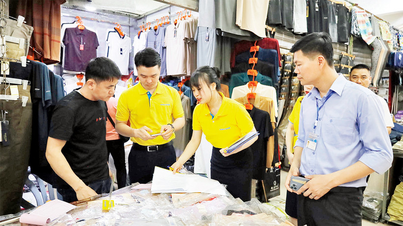 Nhân viên ngân hàng hướng dẫn hộ kinh doanh tại chợ Móng Cái thanh toán không dùng tiền mặt.