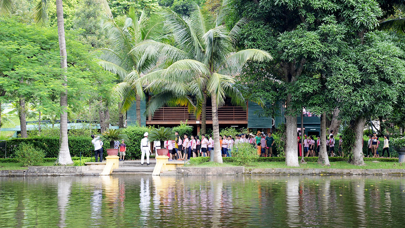 Học sinh tham quan nhà sàn, ao cá Bác Hồ trong Khu Di tích Chủ tịch Hồ Chí Minh tại Phủ Chủ tịch. (Ảnh Yến Kim)