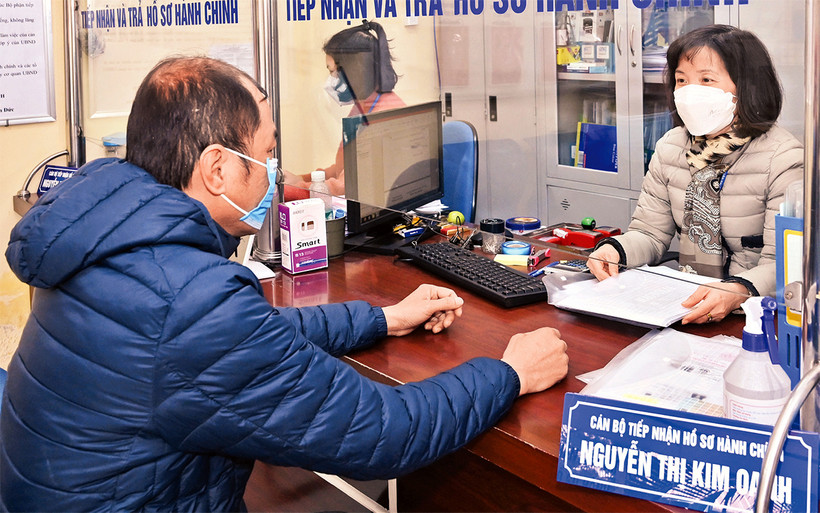 Cán bộ tại Bộ phận “một cửa” UBND phường Nguyễn Du, quận Hai Bà Trưng giải quyết thủ tục hành chính cho người dân. (Ảnh Ðăng Duy)