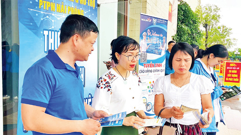 Cán bộ Bảo hiểm xã hội Hải Phòng tuyên truyền chính sách bảo hiểm xã hội tự nguyện, bảo hiểm y tế hộ gia đình tại các phiên giao dịch việc làm. (Ảnh QUANG MINH)