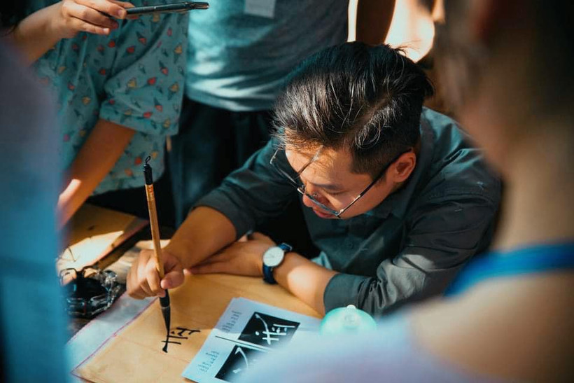 Tác giả, trong một buổi thực hành thư pháp. Ảnh: NVCC