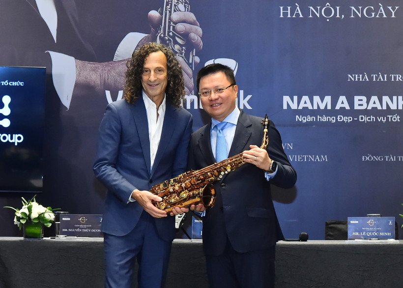Tổng Biên tập Báo Nhân Dân Lê Quốc Minh thay mặt Ban tổ chức nhận quà tặng từ nghệ sĩ Kenny G. Ảnh: Thủy Nguyên