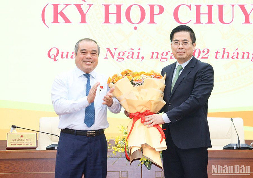 Phó Chủ tịch Thường trực Ủy ban nhân dân tỉnh Quảng Ngãi Trần Hoàng Tuấn tặng hoa chúc mừng tân Chủ tịch Ủy ban nhân dân tỉnh Quảng Ngãi Nguyễn Hoàng Giang.