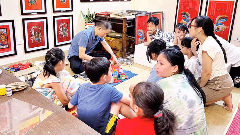 Nghệ nhân Ðào Ðình Chung giới thiệu kỹ thuật làm tranh cho các bạn nhỏ.