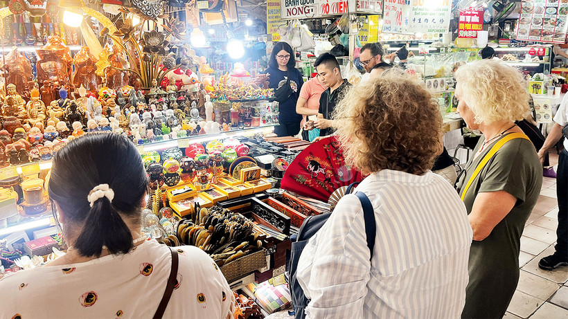 Du khách tham quan gian hàng của tiểu thương tại chợ Bến Thành. (Ảnh CTV)