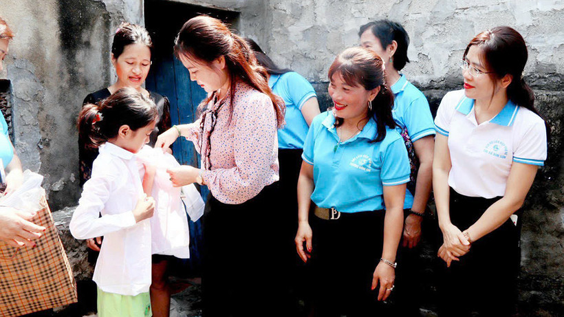 Lãnh đạo Hội Liên hiệp Phụ nữ tỉnh Thanh Hóa và các "Mẹ đỡ đầu" tặng quà cho trẻ mồ côi. (Ảnh THÚY YÊN)