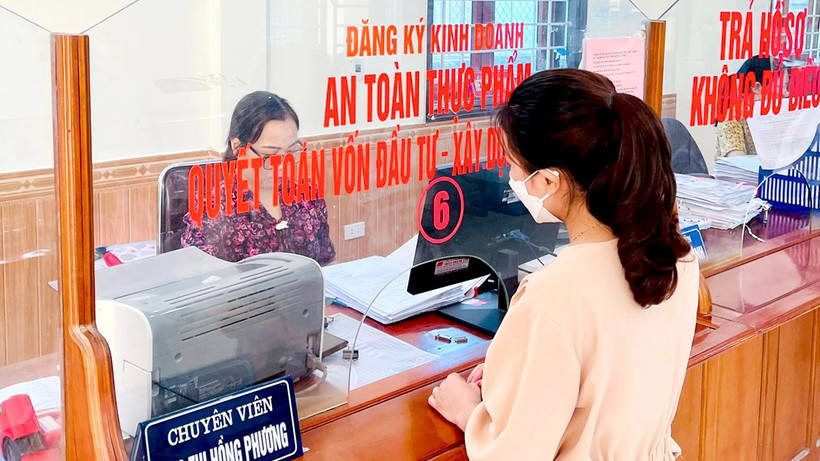 Công chức Bộ phận một cửa huyện Nghi Lộc (Nghệ An) giải quyết thủ tục hành chính cho người dân.