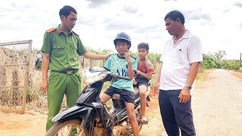Các thành viên nhóm họ Kpuih (làng Trol Ðeng) phối hợp với Công an thị trấn Chư Ty nhắc nhở các em nhỏ về việc điều khiển xe máy khi chưa đủ tuổi là vi phạm pháp luật. 