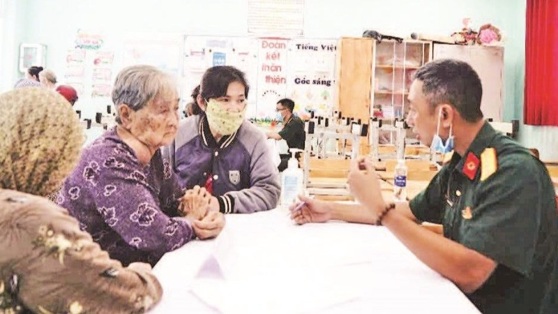 Bác sĩ quân y Phạm Văn Dũng (Cục 12) khám chữa bệnh cho người có công. (Ảnh ANH THẾ)