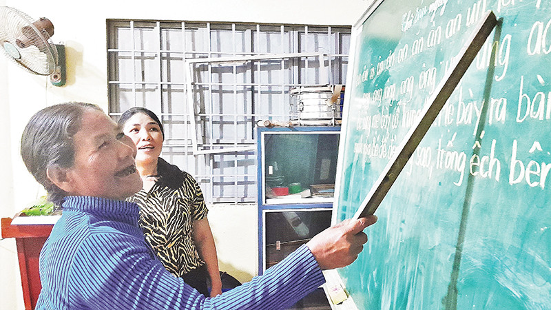 Học sinh lớn tuổi tại lớp học xóa mù chữ tại thôn 6 (xã Long Tân) đang tập đọc.