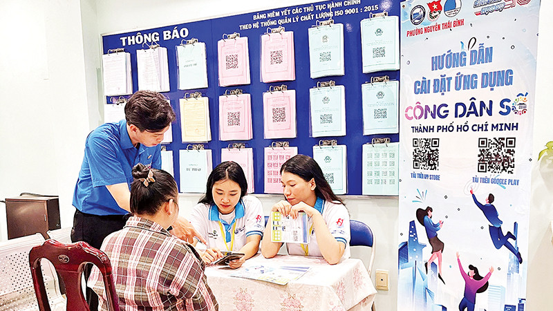Các bạn trẻ hướng dẫn người dân Quận 1 cài đặt và sử dụng ứng dụng “Công dân số Thành phố Hồ Chí Minh”.