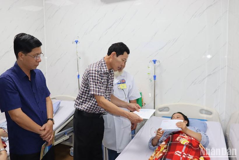 Đồng chí Võ Thanh An thăm hỏi và trao quà cho nữ lao công Võ Thị Lưu.